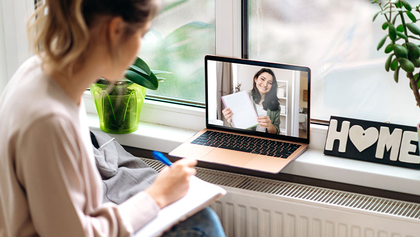 Mujer tomando apuntes durante una reuni&oacute;n online