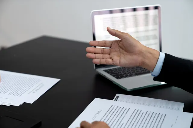 La mano de un abogado señalando un contrato mercantil