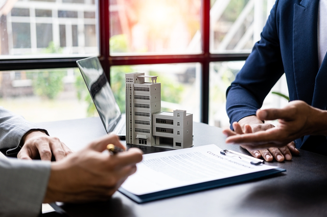 Personas cerrando un contrato relacionado con derecho inmobiliario