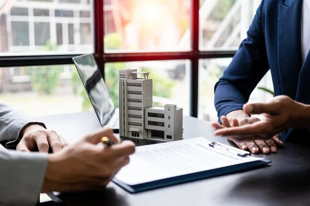 Personas cerrando un contrato relacionado con derecho inmobiliario
