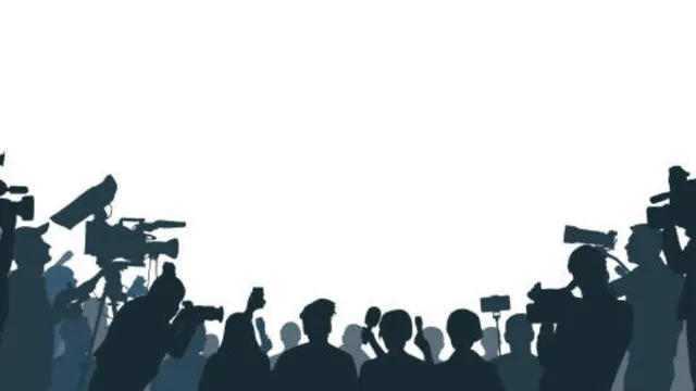 Silhouette of a crowd of sports reporters, photographers, and videographers holding up cameras, microphones, and smartphones at a post-game press conference.