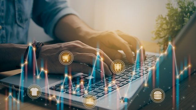 persona de negocios que escribe en un ordenador portátil sobre un gráfico de tendencias de mercado