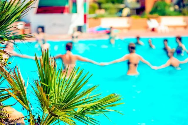 gente haciendo aquagym en la piscina de un hotel