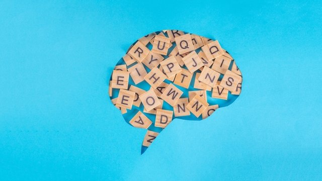contorno de un cerebro sobre un fondo de color azul y con letras mixtas