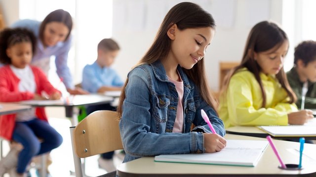 niños sentados en un aula haciendo unos ejercicios escritos