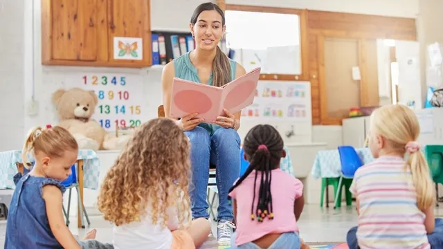 maestra lee en voz alto un cuento a unos estudiantes de Educación Infantil