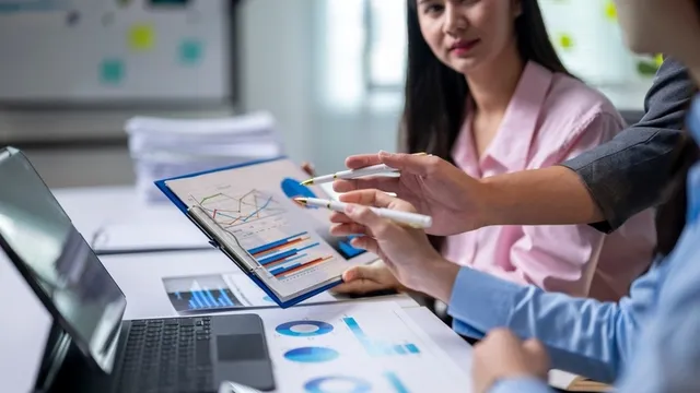 un grupo de personas está discutiendo los datos de unos gráficos y toma decisiones basadas en ellos