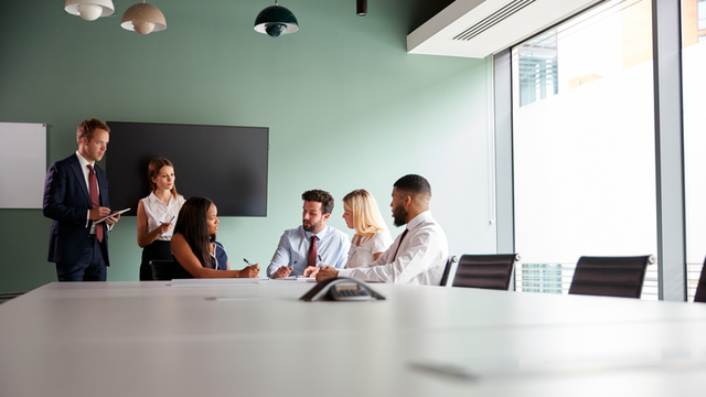 grupo de personas reunido en una sala que colabora en la solución de un proceso de selección