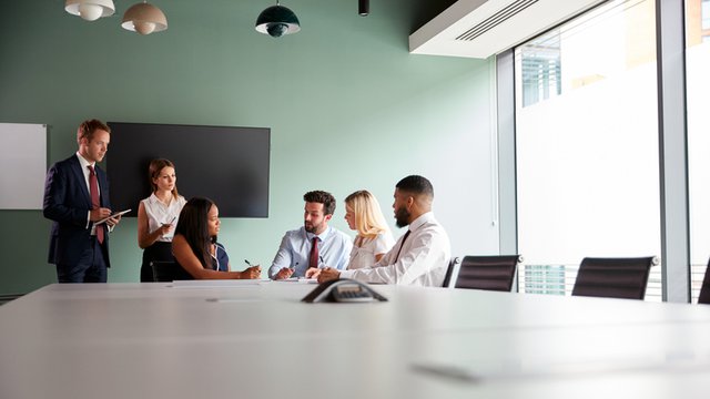 grupo de personas reunido en una sala que colabora en la solución de un proceso de selección