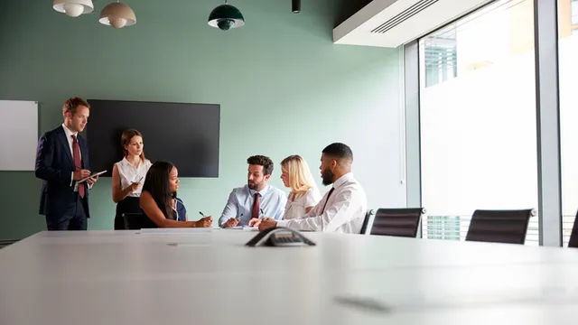 grupo de personas reunido en una sala que colabora en la solución de un proceso de selección