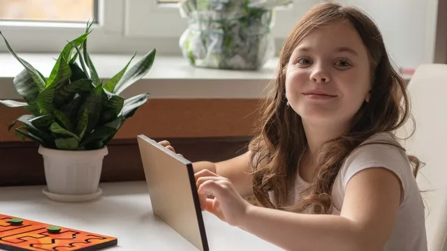 niña pequeña sonríe y sostiene un juguete de entrenamiento interhemisférico en sus manos