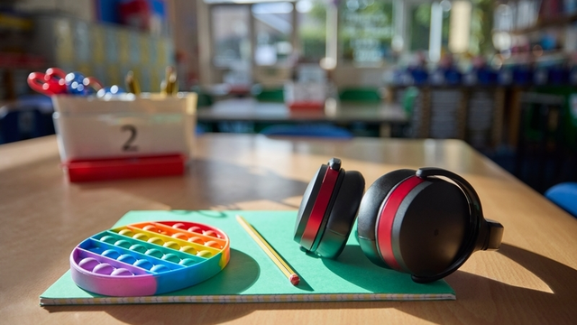 material escolar y auriculares sobre la mesa de un aula