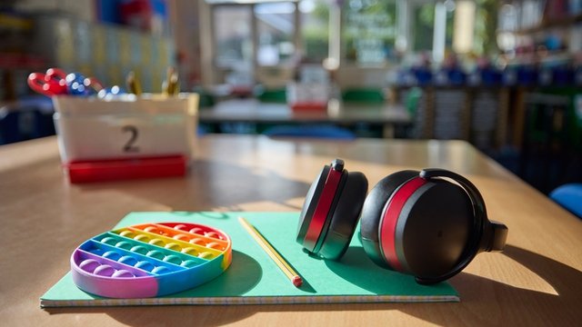 material escolar y auriculares sobre la mesa de un aula