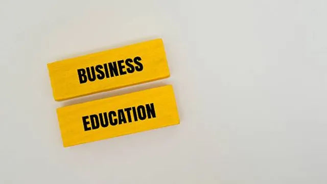 Two yellow wooden blocks placed parallel to each other on a white background, with the words "BUSINESS" and "EDUCATION" printed on them in black capital letters.