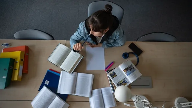 Estudiante de Biblioteca. Vista superior del espacio de trabajo con libros y notas