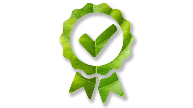 icono de una insignia aprobada hecha de hojas verdes y sobre fondo blanco