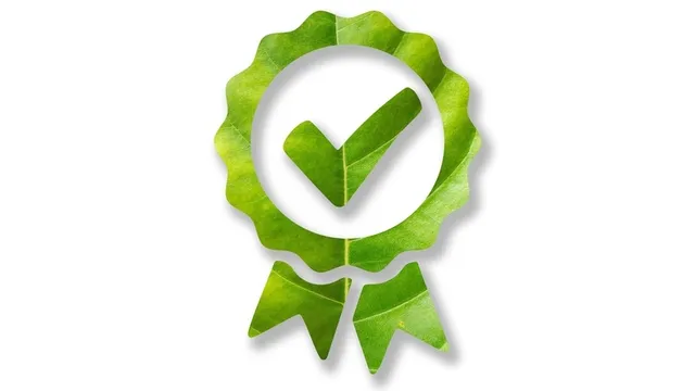 icono de una insignia aprobada hecha de hojas verdes y sobre fondo blanco