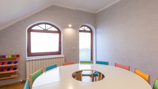 mesa redonda en un aula con sillas puestas alrededor