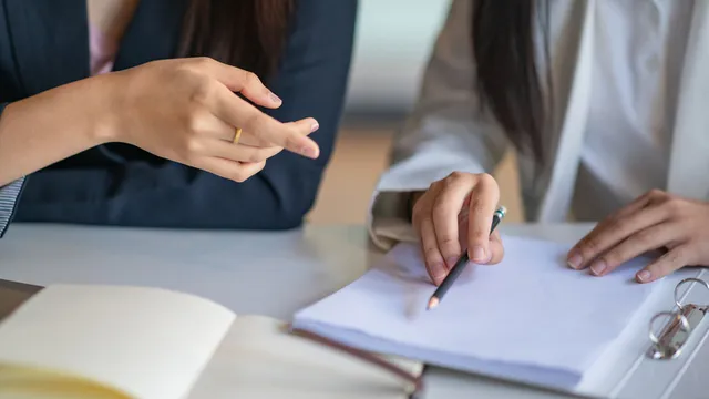 dos personas revisan una documentación antes de firmarla