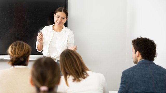 profesora joven dando clase a un grupo de estudiantes