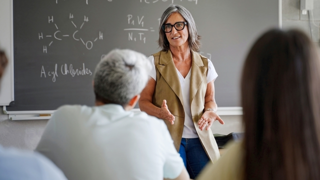 Profesora de Secundaria explica la lección de Química a la clase