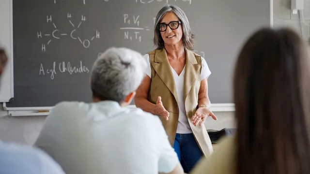 Profesora de Secundaria explica la lección de Química a la clase