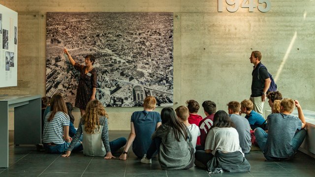 profesor de historia de visita en un museo con sus alumnos