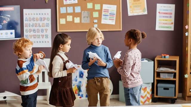Grupo de cuatro niños interactuando en un aula durante el descanso