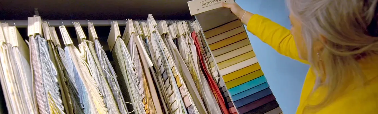 Mujer experta en diseño de interiores eligiendo telas de diferentes colores y texturas
