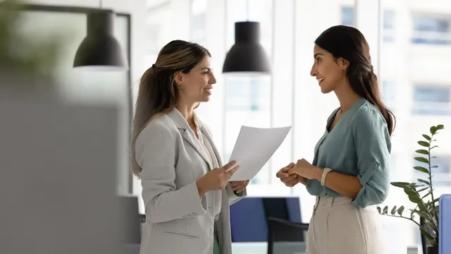 dos mujeres mantienen una conversación en una oficina