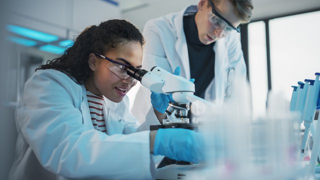 chica observando a través de un microscopio