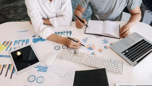 dos personas repasan unos gráficos