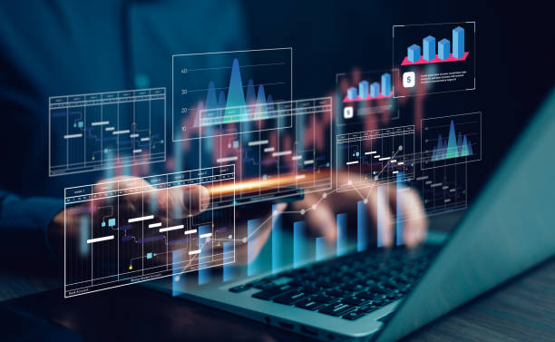 A person types on a laptop while digital data visualisations including Gantt charts, bar graphs, and financial analytics float above the keyboard.
