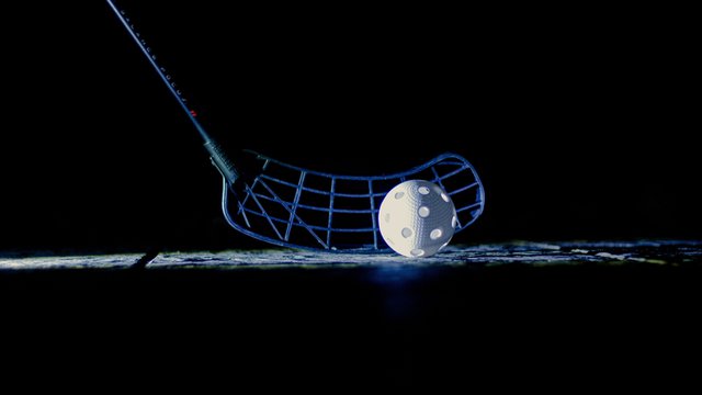 jugador del floorball coloca la pelota en el suelo con ayuda del stick