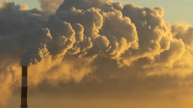 la chimenea de una fábrica liberando emisiones de carbono