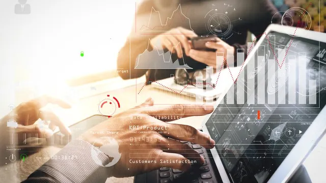 dos personas trabajan con su ordenador y móvil en el análisis de datos de negocio
