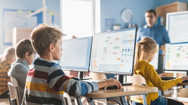 maestro dando clases de ofimática a estudiantes de primaria