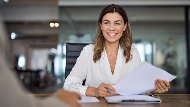 directora de recursos humanos sonriente y sentada en una sala de reuniones