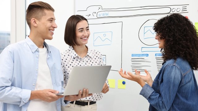 un equipo de tres personas desarrolla un diseño de la interfaz de usuario