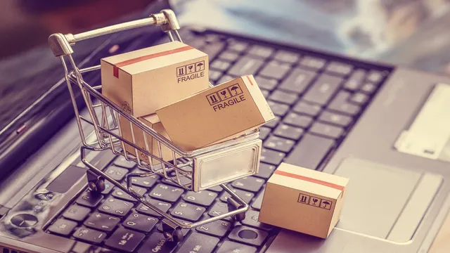 carro de la compra lleno de pedido hechos a un e-commerce sobre el teclado de un ordenador portátil
