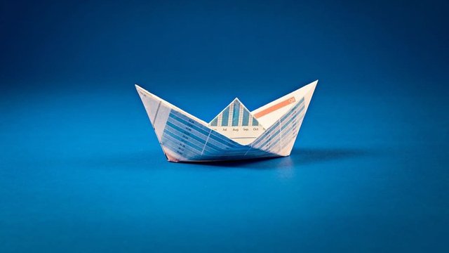 barco de papel sobre fondo azul