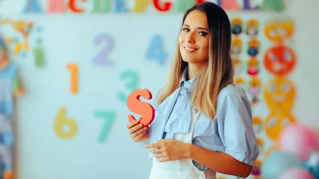 profesional del habla sostiene la letra s en su mano