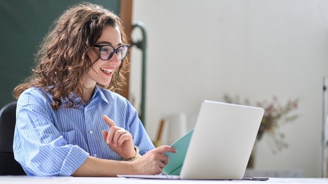 directora de un centro educativo usando una tablet para hacer una videoconferencia