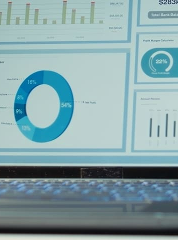 sala de juntas corporativa vac&iacute;a por la noche con pantalla digital de m&eacute;tricas de rendimiento, gr&aacute;ficos y proyecciones en la computadora port&aacute;til