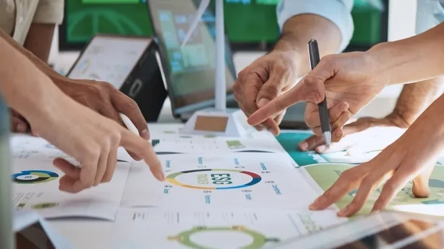 un equipo de trabajo se ha reunido en una sala para revisar unos documentos