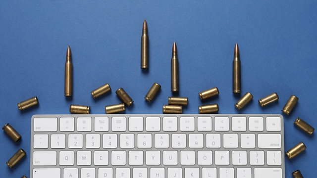 balas y teclado de ordenador sobre fondo azul
