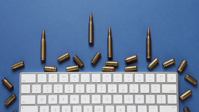 balas y teclado de ordenador sobre fondo azul
