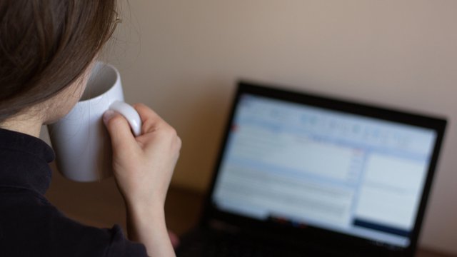 traductora que trabaja con la herramienta CAT y bebe de una taza blanca