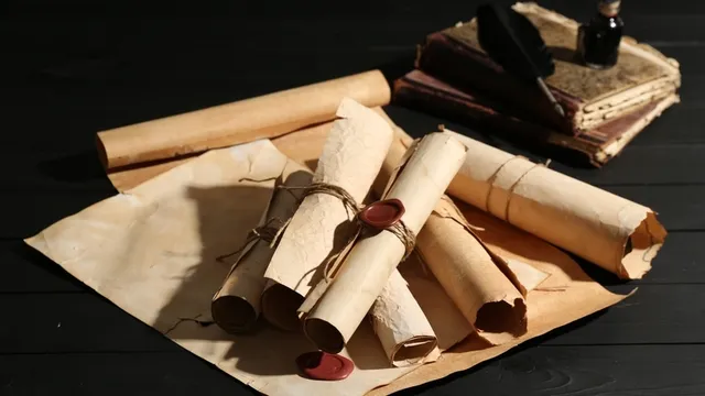 Muchos viejos rollos y libros en la mesa de madera negra, en primer plano