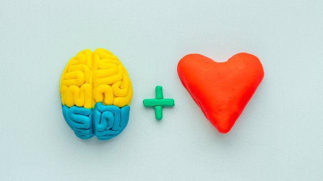 conos de un cerebro, un signo de suma y un corazón hechos de plastilina